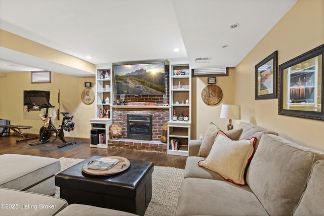 living area featuring a brick fireplace, visible vents, wood finished floors, and recessed lighting