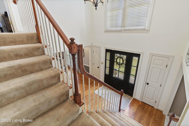 foyer entrance with an inviting chandelier, stairs, baseboards, and wood finished floors