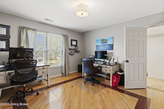 office area with baseboards, visible vents, and hardwood / wood-style floors