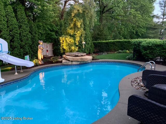 view of pool featuring a fenced in pool, a water slide, and a fenced backyard