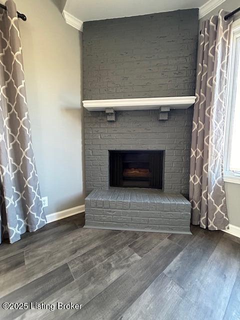 room details with ornamental molding, a fireplace, baseboards, and wood finished floors