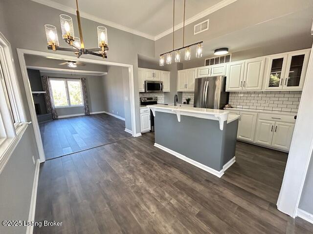 kitchen with dark wood-style flooring, white cabinets, visible vents, and appliances with stainless steel finishes