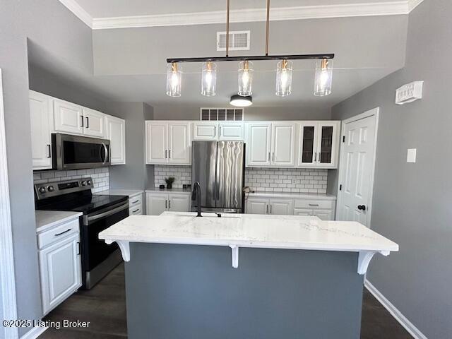 kitchen with visible vents, appliances with stainless steel finishes, crown molding, and a sink