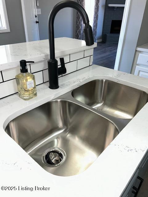 details with light stone countertops and a sink