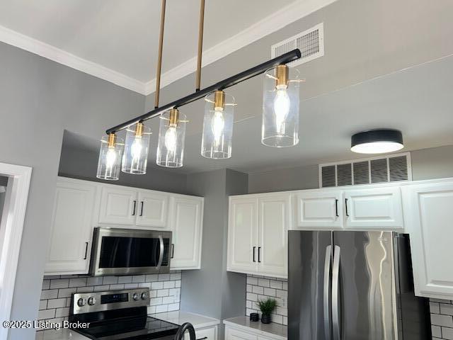 kitchen featuring stainless steel appliances, white cabinets, visible vents, and decorative backsplash