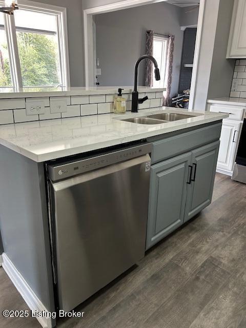 kitchen with a wealth of natural light, dishwasher, backsplash, and a sink