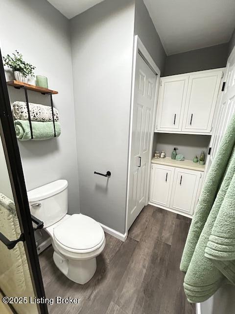 bathroom with toilet and wood finished floors