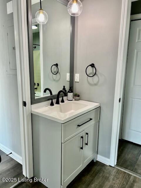 bathroom featuring baseboards, wood finished floors, and vanity