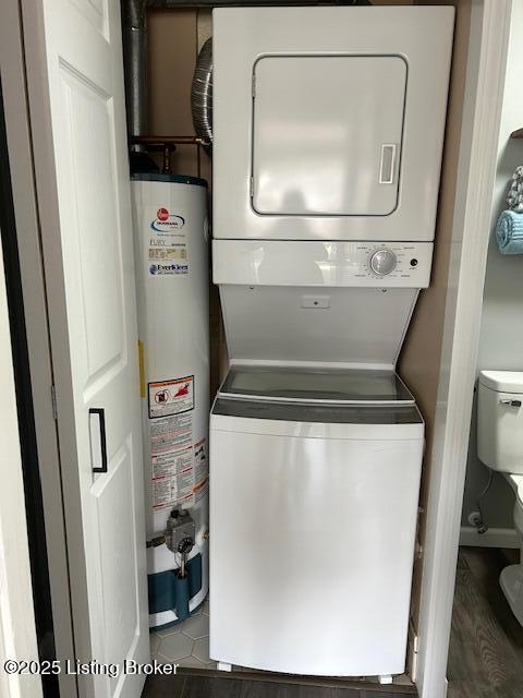 clothes washing area with gas water heater, stacked washer / drying machine, and laundry area