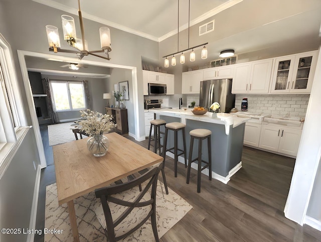 dining room featuring visible vents, crown molding, baseboards, an inviting chandelier, and dark wood-style floors