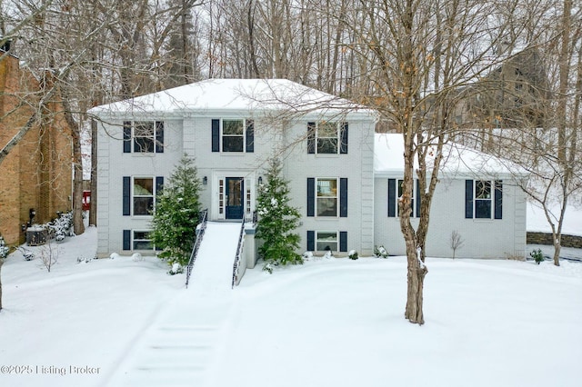 colonial house featuring brick siding