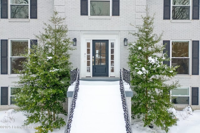 view of exterior entry featuring brick siding