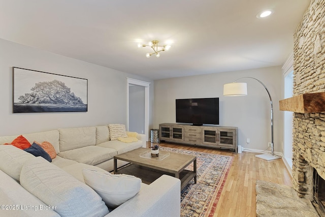 living area featuring recessed lighting, a fireplace, wood finished floors, and baseboards