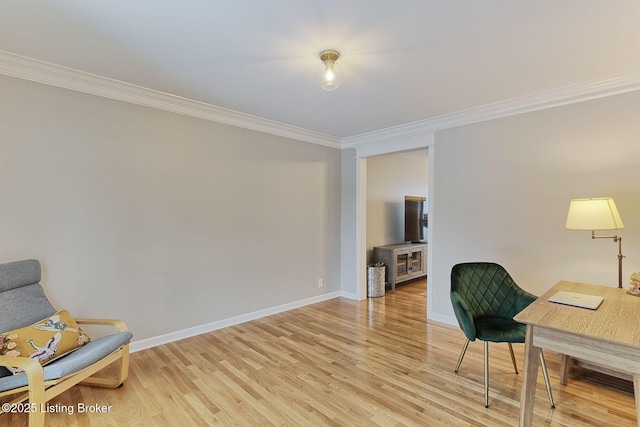 sitting room with light wood-style floors, baseboards, and crown molding