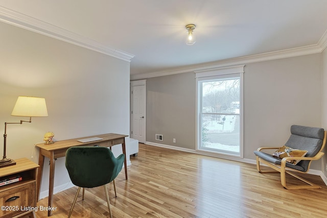 home office featuring light wood finished floors, baseboards, visible vents, and ornamental molding