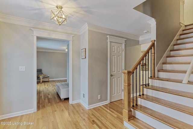 staircase with crown molding, a chandelier, wood finished floors, and baseboards