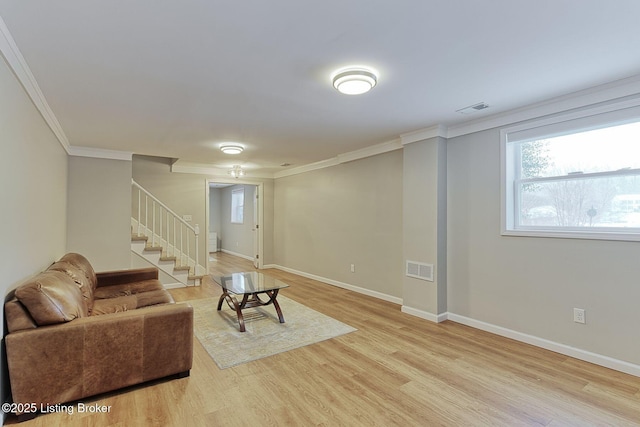 living area with visible vents, baseboards, stairs, light wood-type flooring, and crown molding