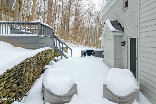 yard layered in snow featuring stairway and a wooden deck