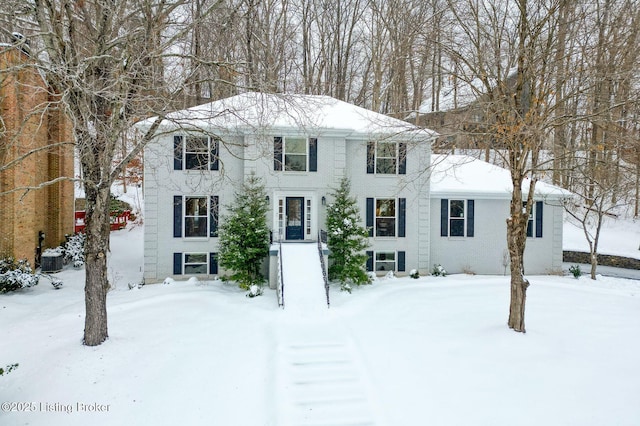 view of front of house featuring cooling unit and brick siding