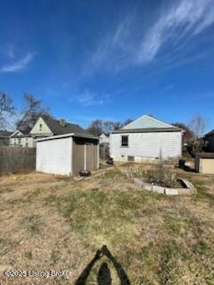 exterior space featuring a shed, fence, an outbuilding, and a yard