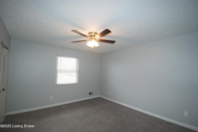 unfurnished room featuring ceiling fan, baseboards, dark carpet, and a textured ceiling