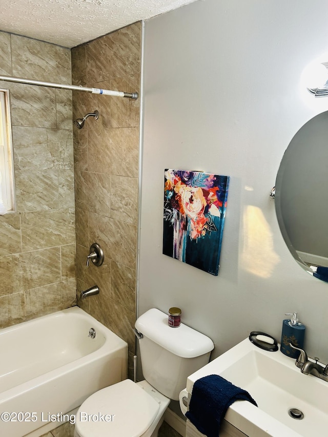 full bath featuring a textured ceiling, shower / bath combination, a sink, and toilet