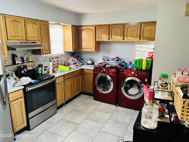 interior space featuring light tile patterned flooring, a sink, a textured ceiling, separate washer and dryer, and laundry area