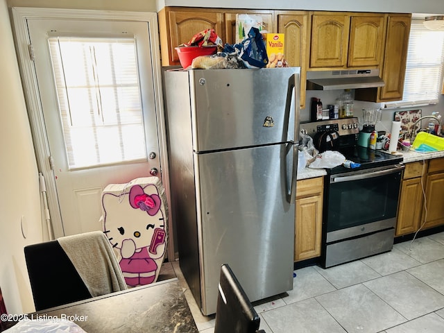 kitchen featuring appliances with stainless steel finishes, a healthy amount of sunlight, brown cabinets, and under cabinet range hood