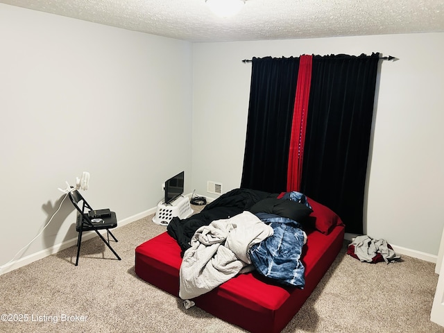 carpeted bedroom with baseboards, visible vents, and a textured ceiling