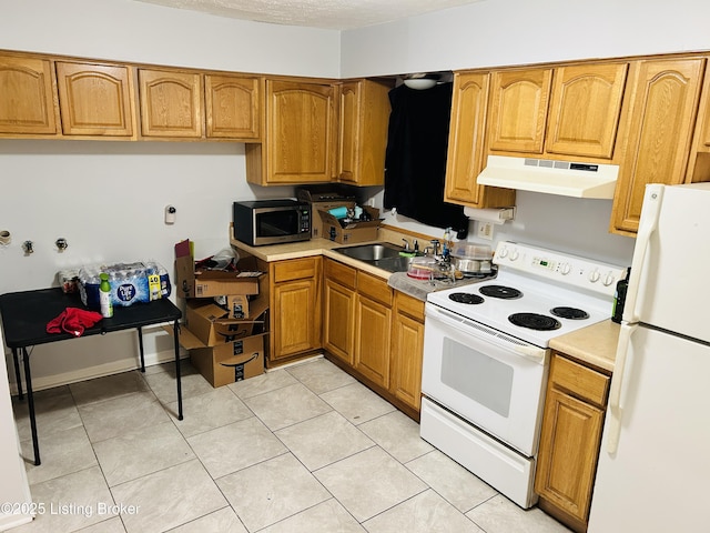 kitchen featuring under cabinet range hood, white appliances, a sink, light countertops, and brown cabinets