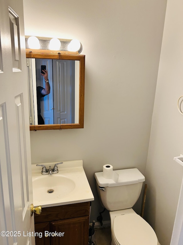 half bath featuring toilet and vanity