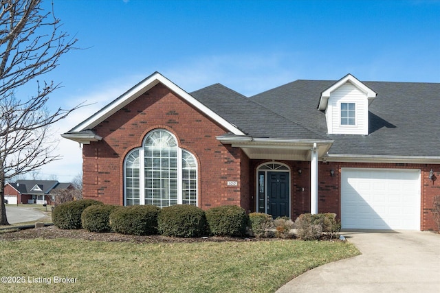 view of front of property with a garage, brick siding, driveway, and a front lawn