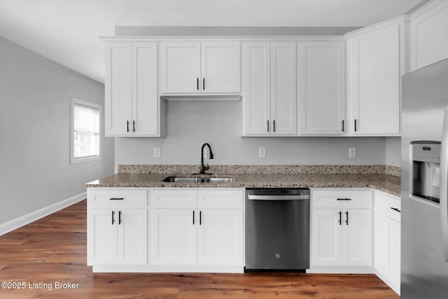 kitchen with appliances with stainless steel finishes, a sink, and white cabinets