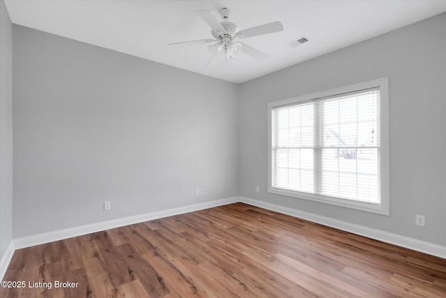 unfurnished room featuring visible vents, baseboards, and wood finished floors