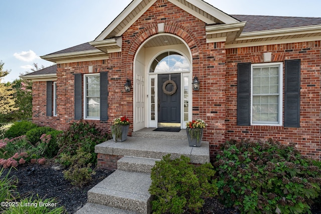 entrance to property with brick siding and roof with shingles