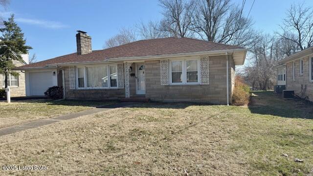 view of front of property with an attached garage, a chimney, and a front lawn