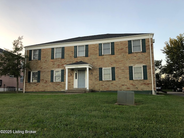 view of front of house featuring a front lawn and brick siding