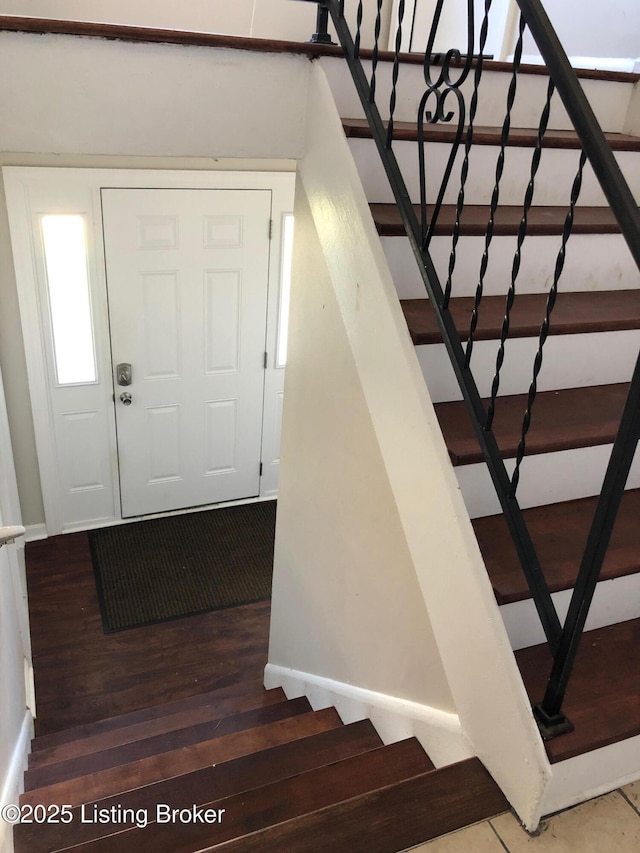 stairway featuring baseboards and wood finished floors