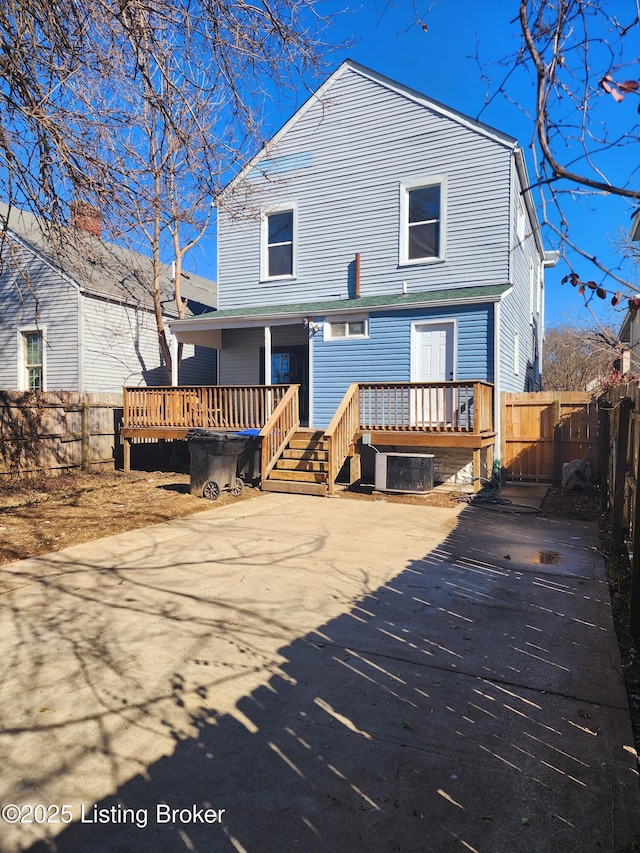 rear view of property featuring central air condition unit, fence, and a wooden deck