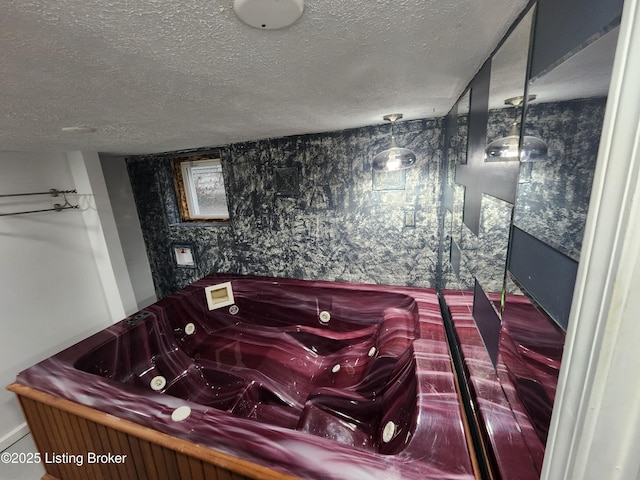 bathroom featuring a jetted tub and a textured ceiling