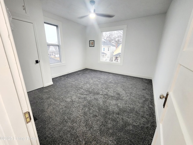 bedroom with dark colored carpet, multiple windows, a ceiling fan, and baseboards