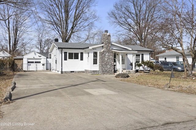 single story home with an outbuilding, roof with shingles, a detached garage, and a chimney