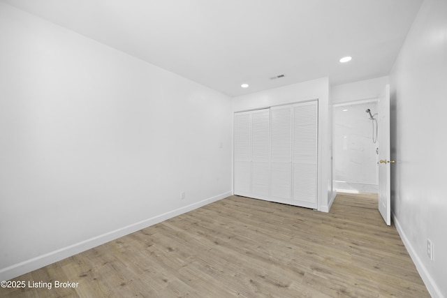 unfurnished bedroom with light wood finished floors, visible vents, baseboards, a closet, and recessed lighting