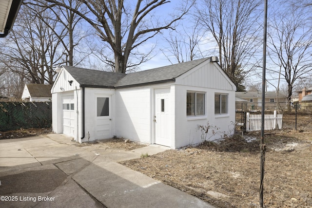 garage with concrete driveway and fence