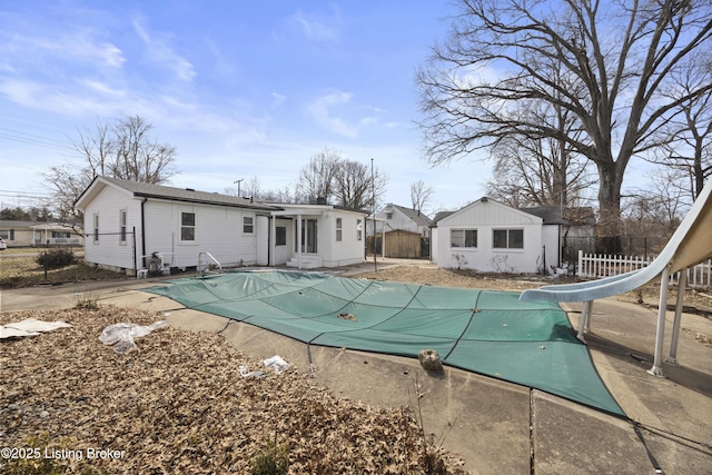 rear view of property with a fenced in pool, a patio area, and fence