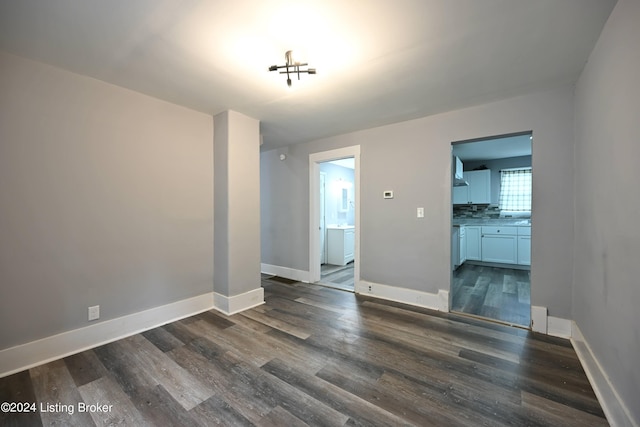 interior space with dark wood-style flooring and baseboards