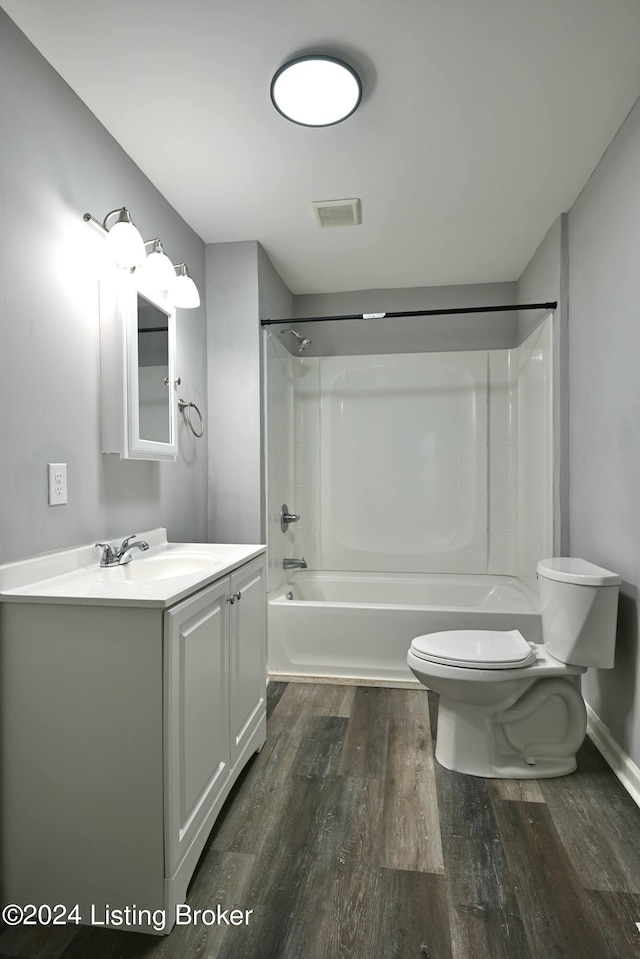 bathroom with toilet, wood finished floors, visible vents, vanity, and tub / shower combination