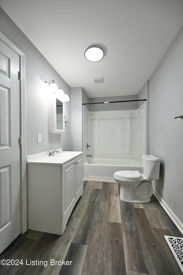 bathroom featuring toilet, wood finished floors, visible vents, vanity, and shower / bathing tub combination