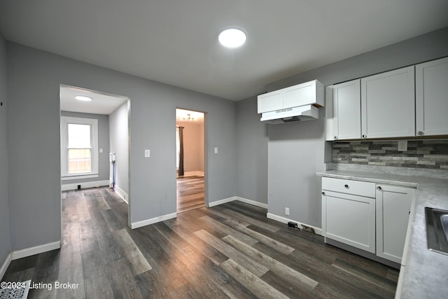 kitchen with light countertops, dark wood-style flooring, white cabinets, and backsplash