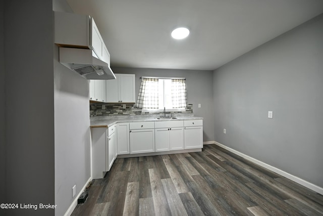 kitchen featuring baseboards, white cabinets, dark wood-type flooring, light countertops, and backsplash